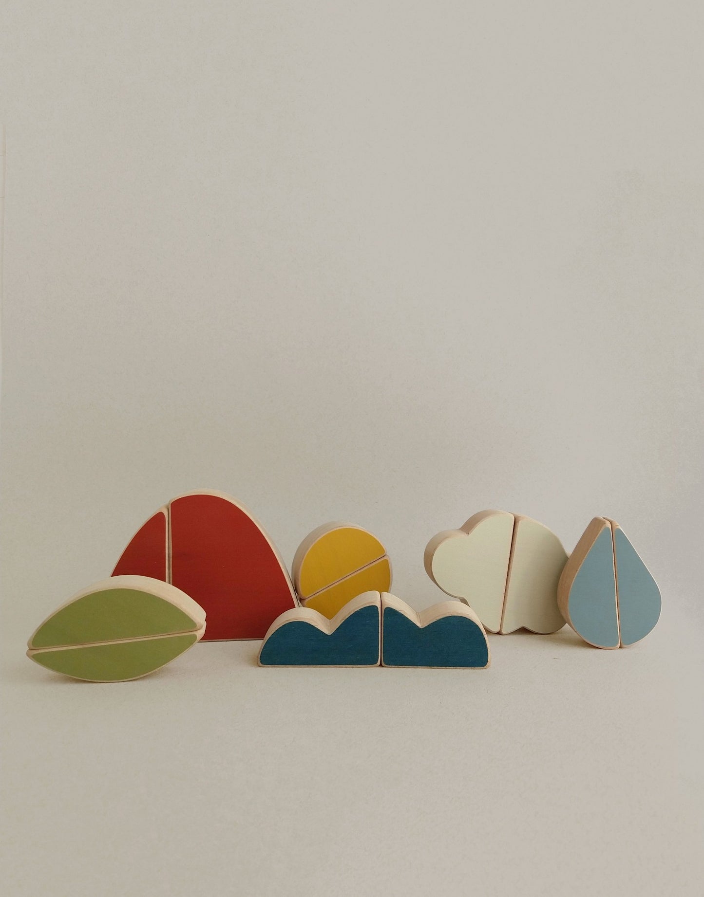 wooden toy puzzle with a mountain, a cloud, a leaf, sun and sea to  encourage slow play and exploration from an early age