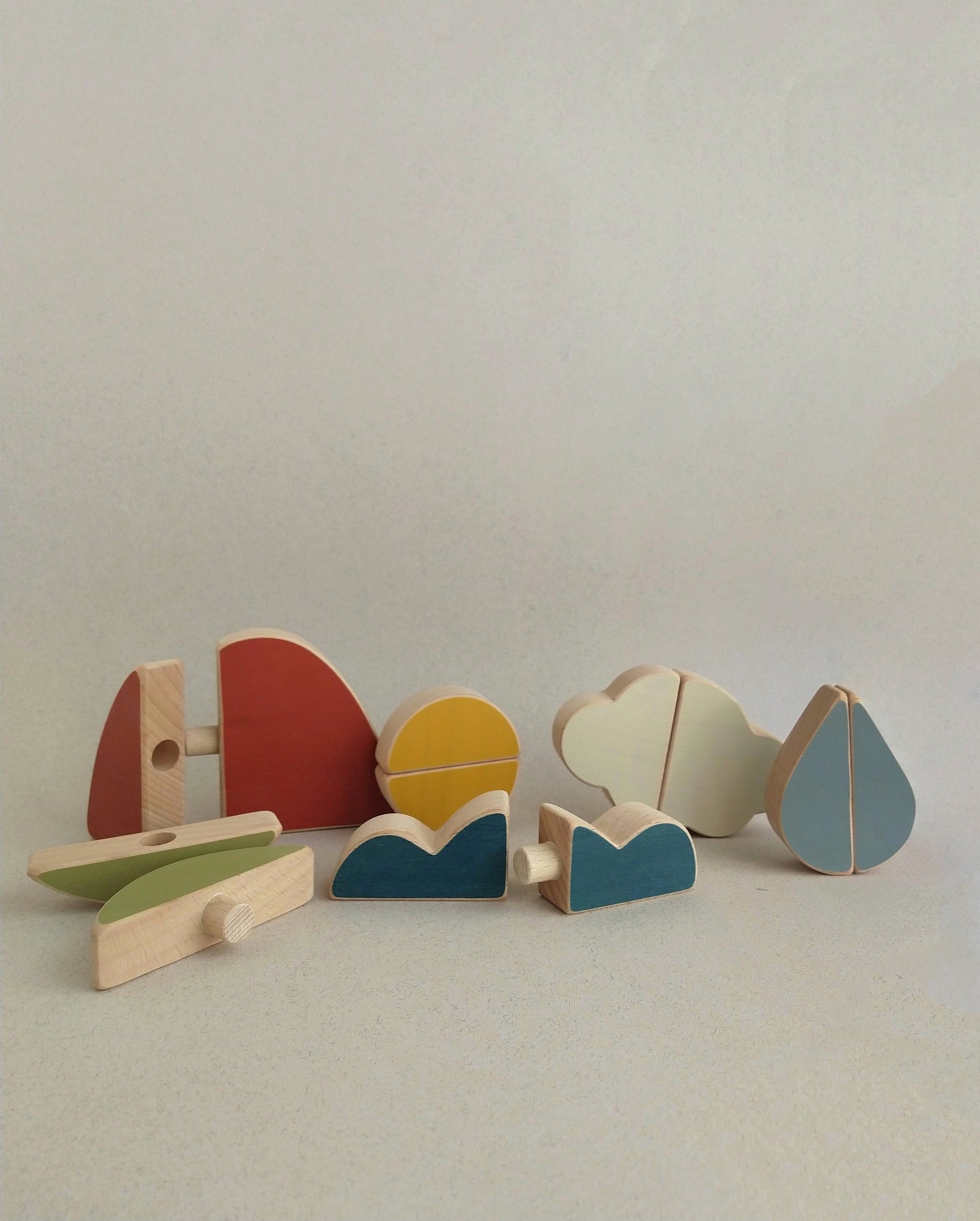 wooden toy puzzle with a mountain, a cloud, a leaf, sun and sea to  encourage slow play and exploration from an early age