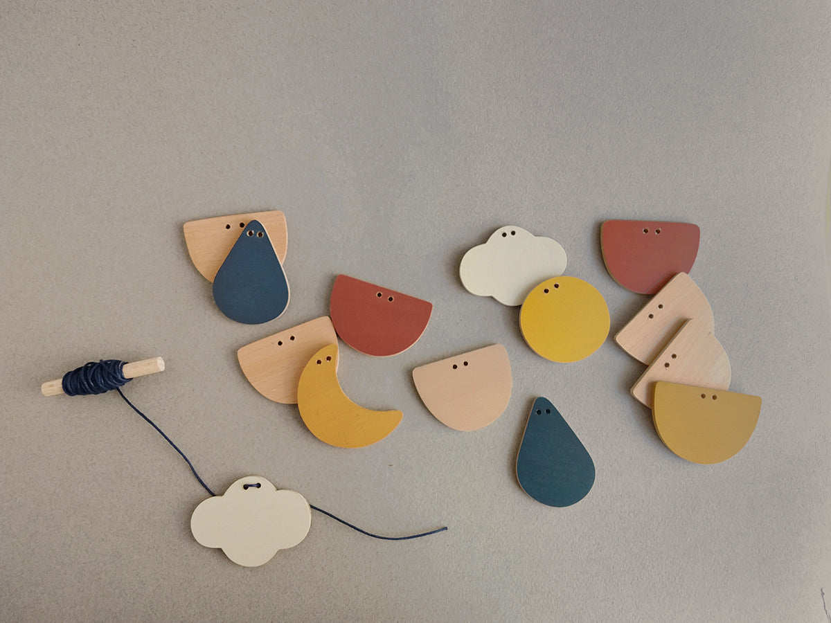 A DIY wood garland with sky elements both painted and natural for crafty family time!