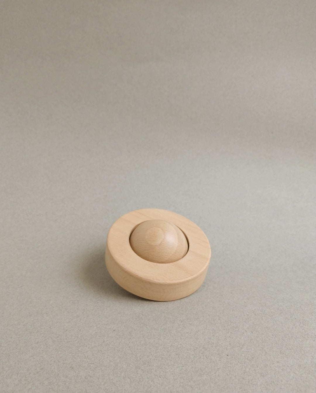 A minimal yet playful wooden teether for babies.