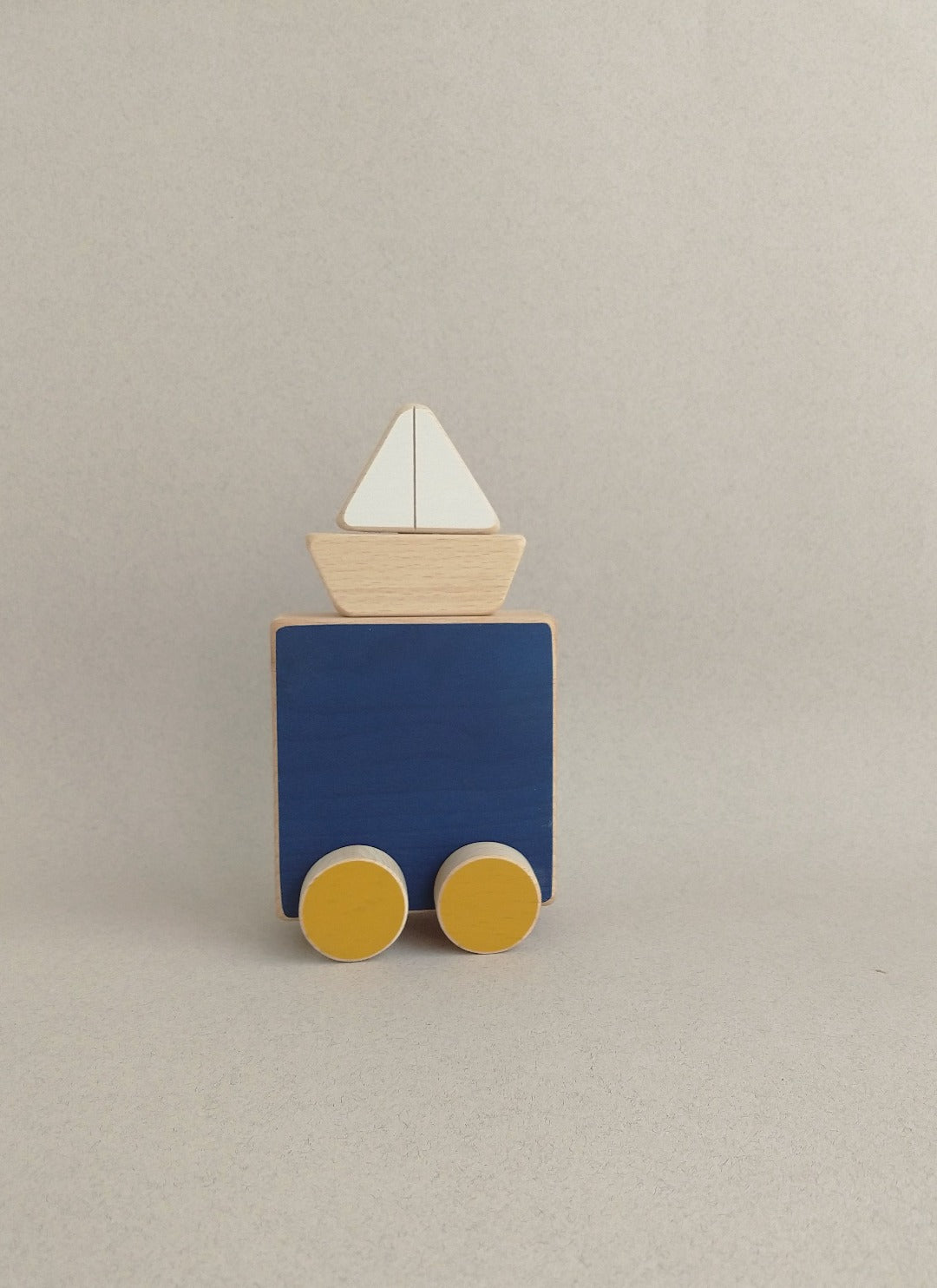 A poetic wooden toy on wheels (with a sea an a boat) drawn from the world of illustration.